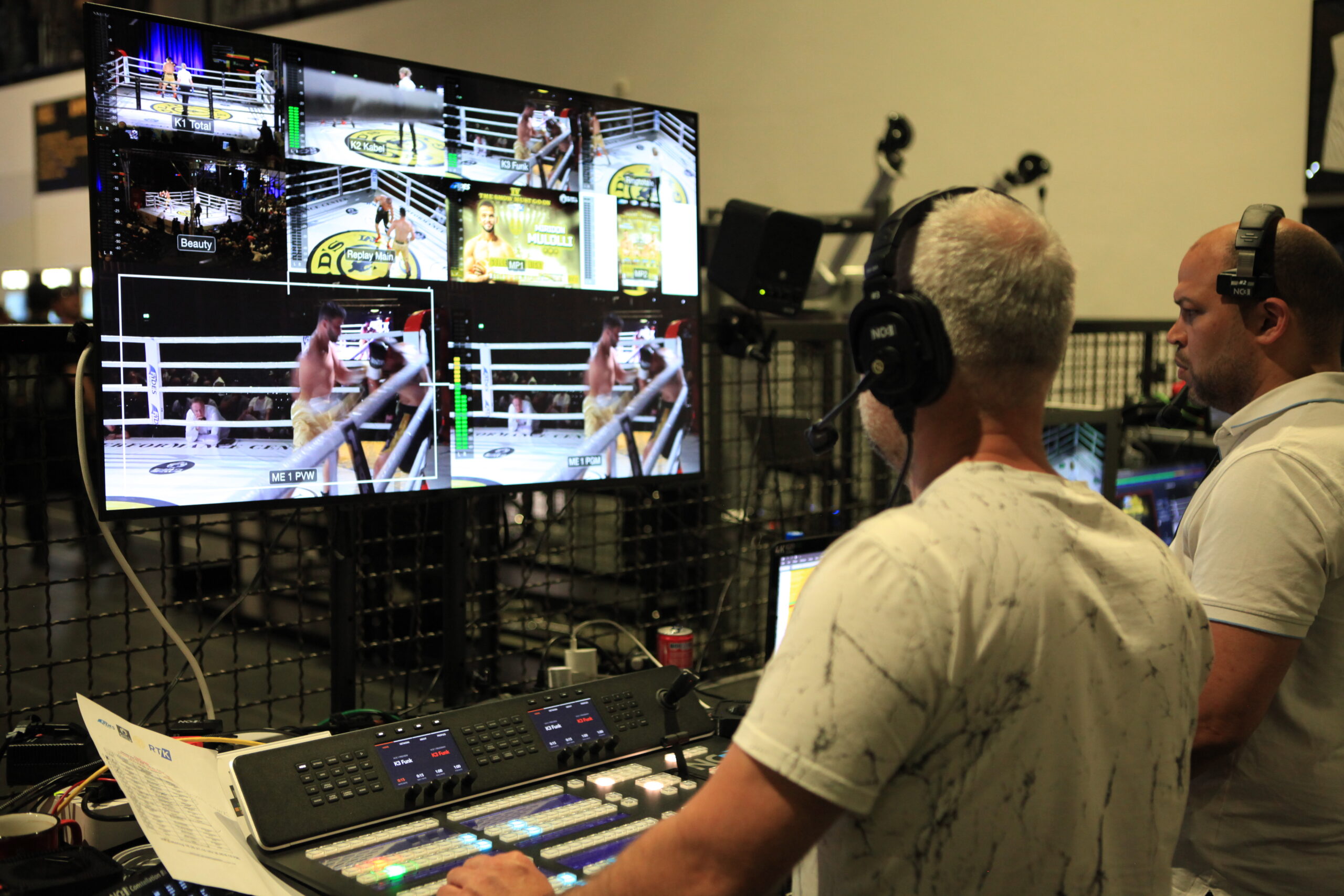 Live-Bildregie bei einem Boxevent: Techniker steuern Multi-Cam-Produktion mit großem Monitor und professionellem Video-Mixer