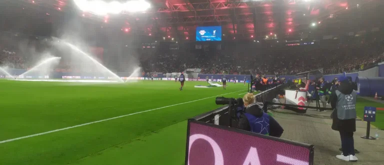 Kamerafrau filmt RB Leipzig Champions League Spiel im Stadion mit Pyrotechnik-Effekten