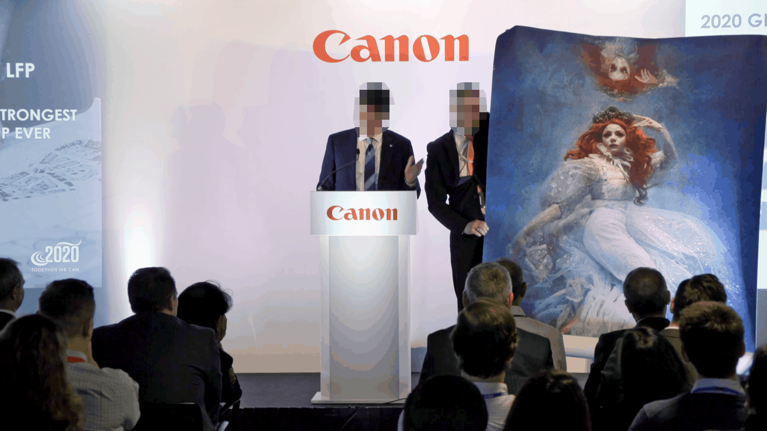 Canon Konferenz 2020: Redner am Podium mit großem Kunstwerk und Publikum
