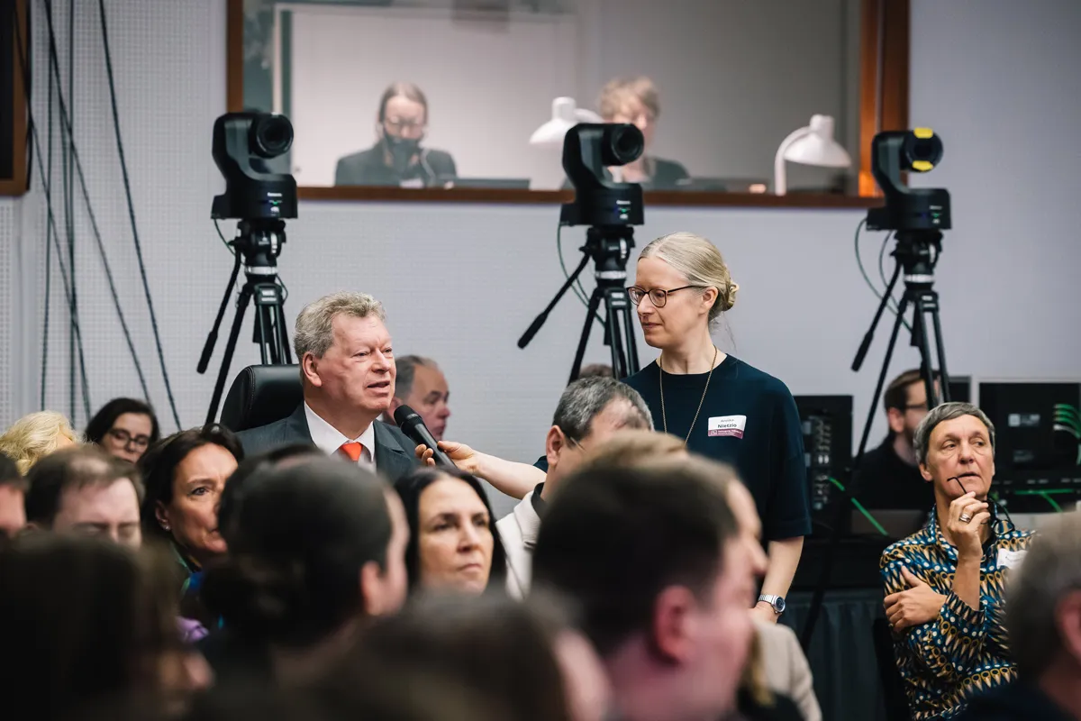 Jürgen Dusel und Gebärdensprachdolmetscherin bei barrierefreiem hybriden Event mit Live-Streaming