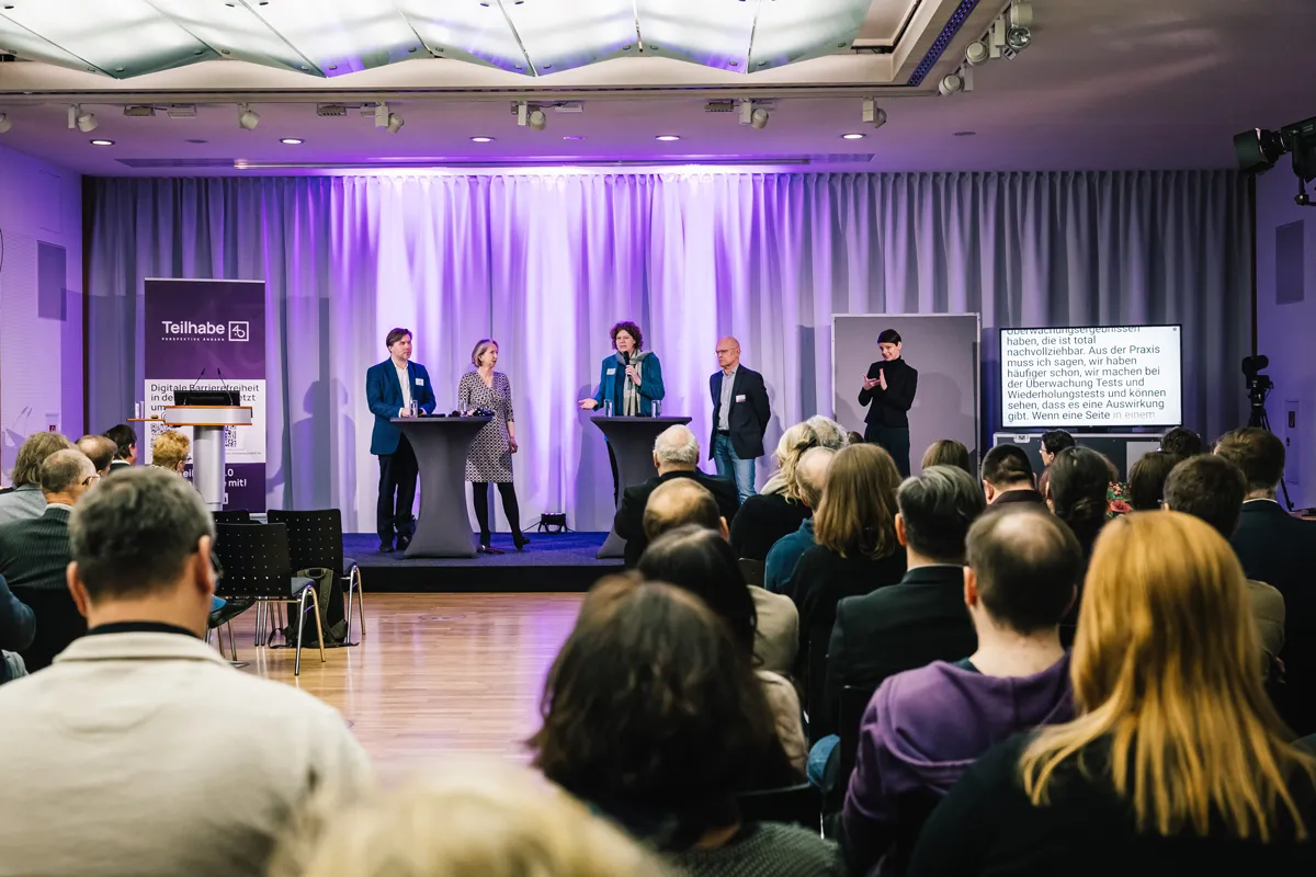 Jürgen Dusel und Gebärdensprachdolmetscherin bei barrierefreiem hybriden Event mit Live-Streaming