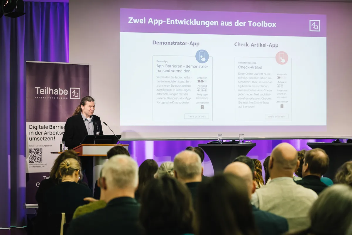 Jürgen Dusel und Gebärdensprachdolmetscherin bei barrierefreiem hybriden Event mit Live-Streaming