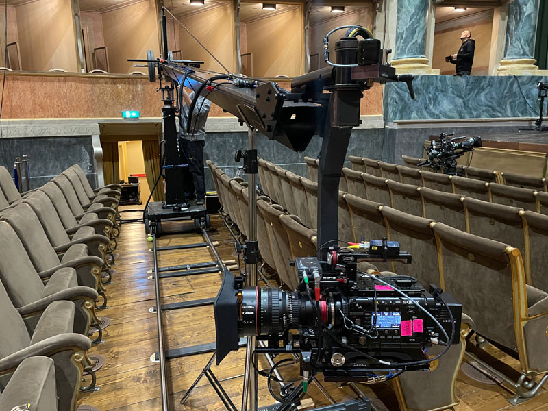 Kamerakran mit professioneller Filmkamera in historischem italienischem Konzertsaal während Videoproduktion
