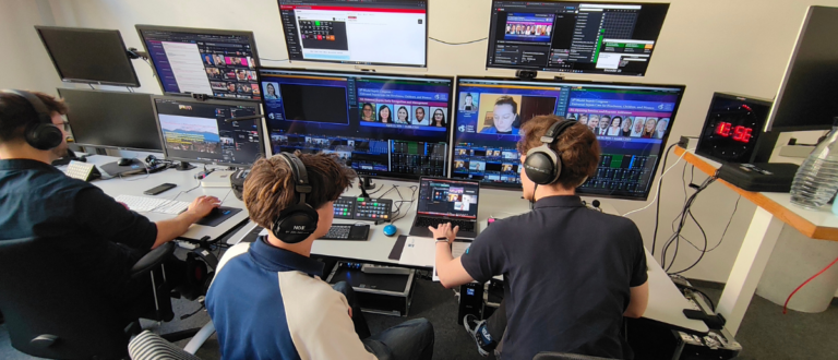 Streaming-Regie-Team mit Kopfhörern vor Monitoren bei Live-Event-Produktion im Studio